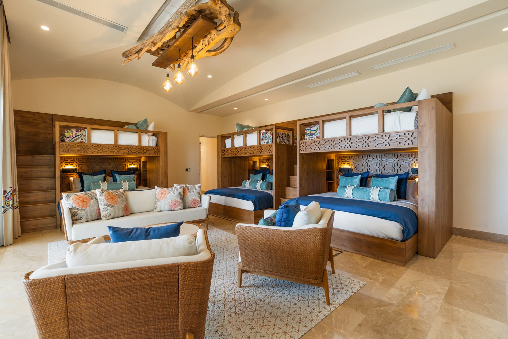 The bunk room -- three custom bunk units sleeping nine children beneath a Matapalo chandelier, with ocean views