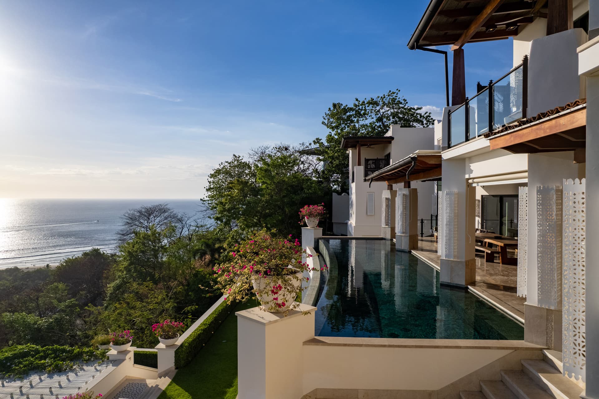 Morning sun on Villa Luciérnaga's infinity pool and bougainvillea terraces above Tamarindo Bay
